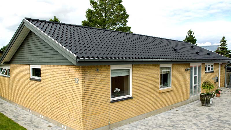 Sorte betontagsten på gul murstensvilla