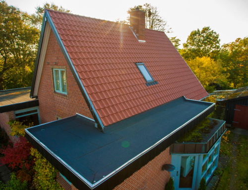 Nyt tagpap føres op under det eksisterende tag, så man sikre en tæt løsning.