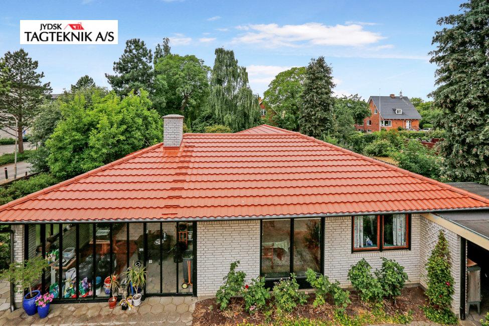 Grå murstensvilla med rødt tag