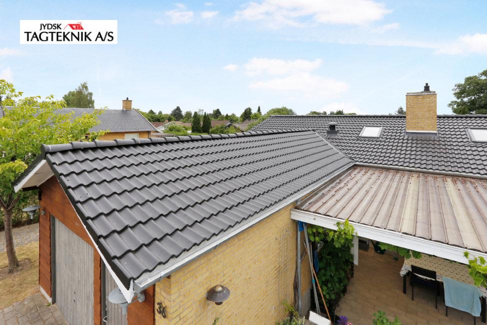 Gul murstensvilla med garage og overdækket terasse