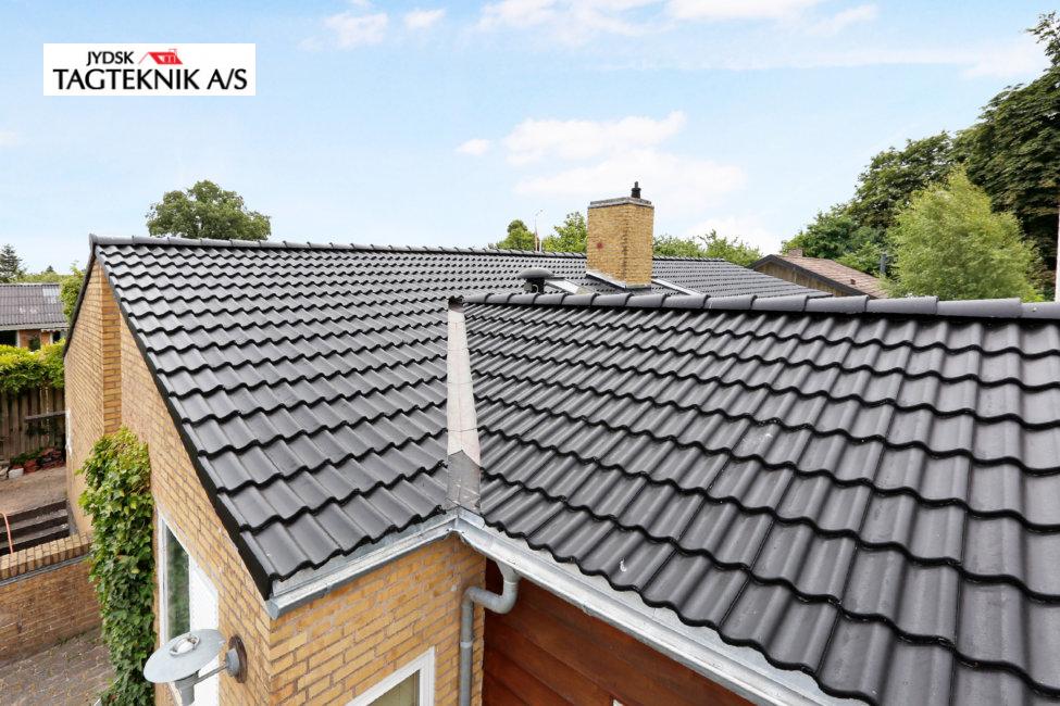 Sort tag på gul murstensvilla