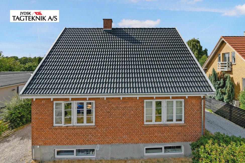 Sort decra tag på rød murstensvilla
